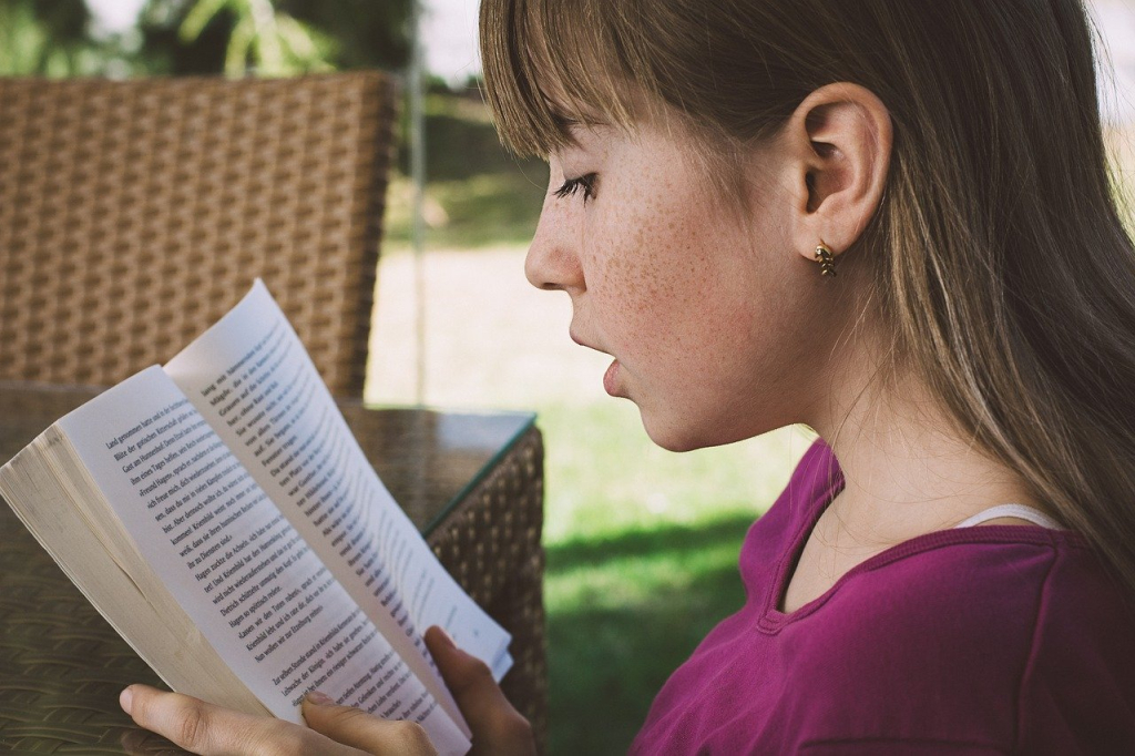 Young girl is reading a book.