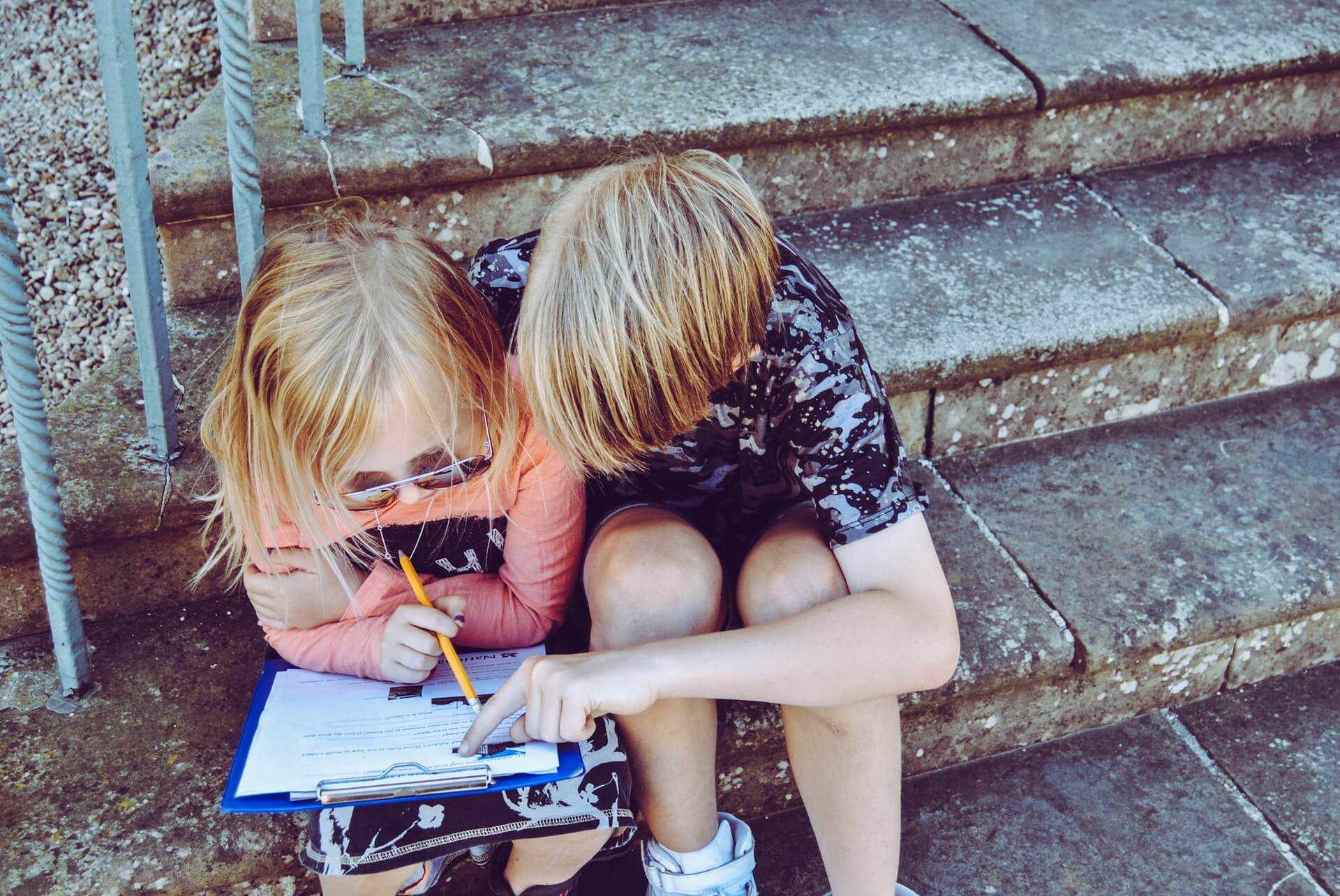A boy is helping a girl with her homework.