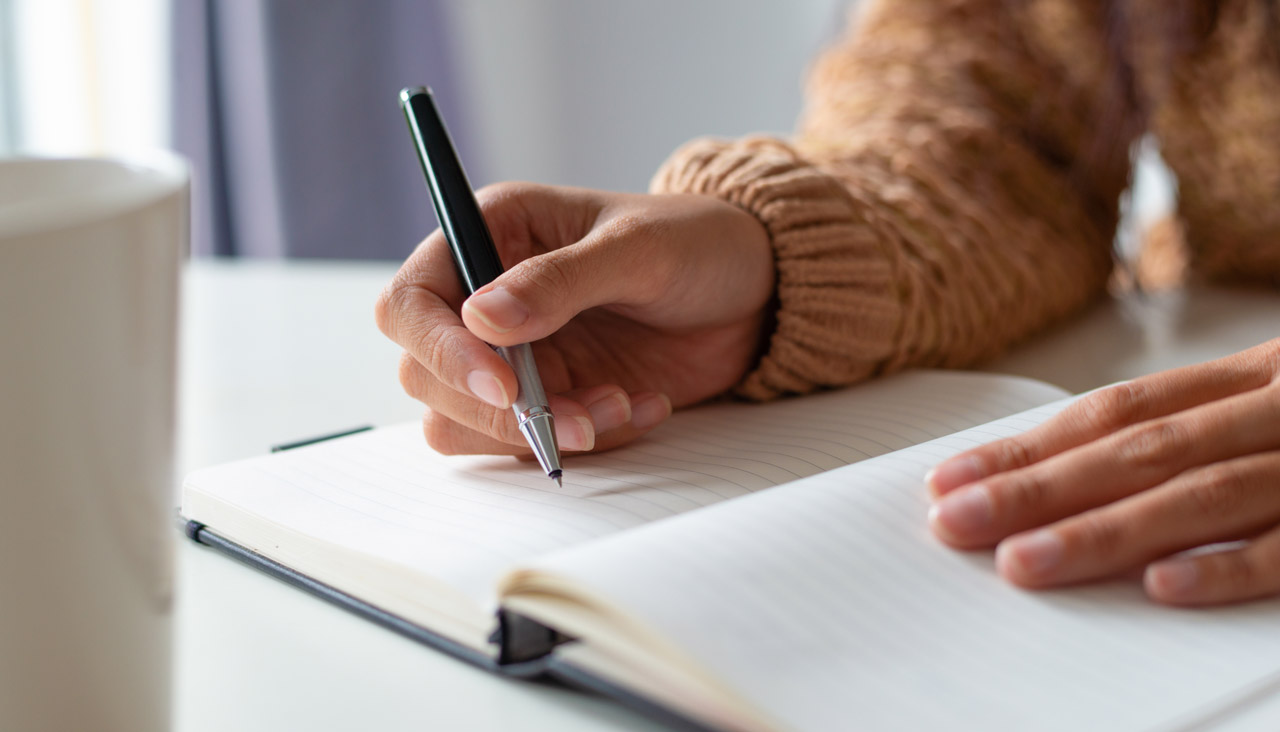 Woman Sitting at the Table and Planning Schedule