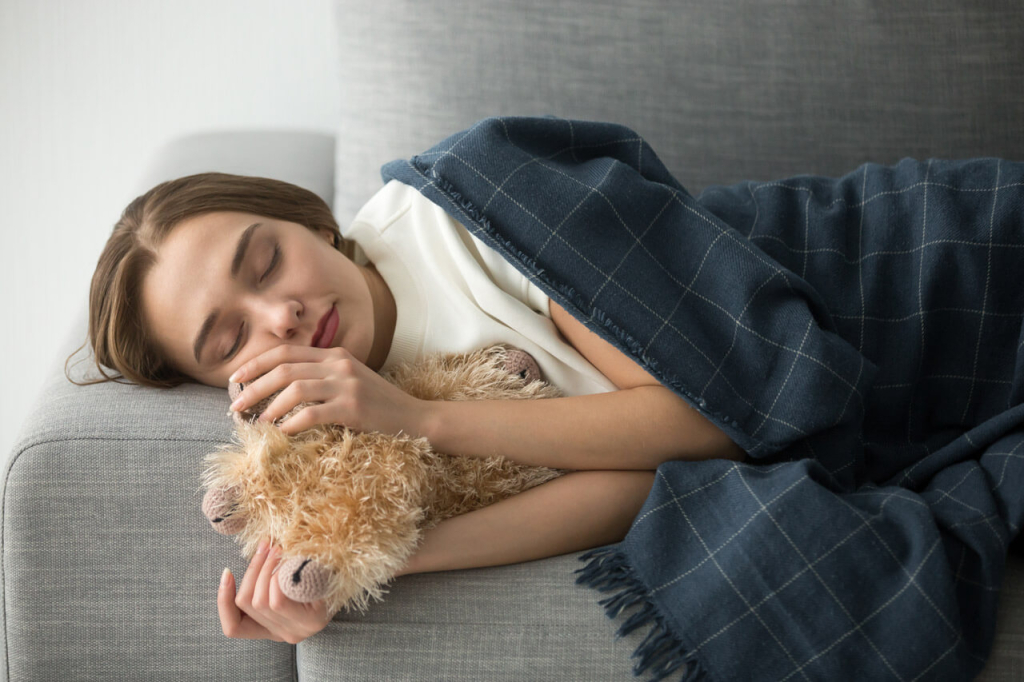 Woman Sleeping on the Comfortable Sofa Hugging a Soft Toy.