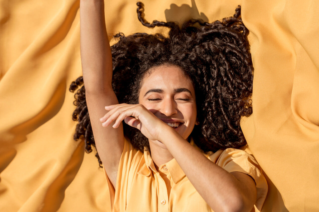 Smiling Woman Lying on the Yellow Cloth.