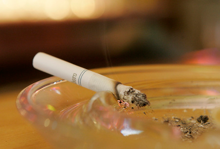 A smouldering cigarette in an ashtray.