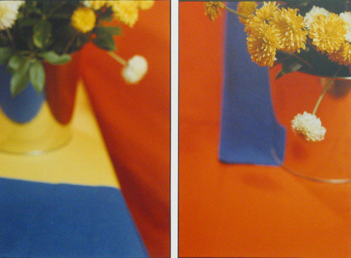 Two vase of flowers on blue, blue, orange, fabric.