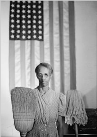 Ella Watson photo standing in front of the American flag inside of the FSA building.