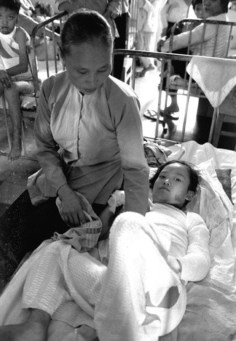 Phan Tai Kim Phuc, 9, is comforted by her mother in a Saigon, Vietnam, hospital, two days after she was severely burned during a misplaced napalm attack on her village, June 10, 1972