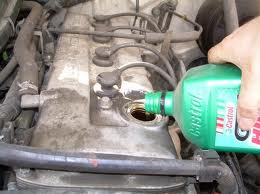 Lube oil being poured into the engine part of an automobile