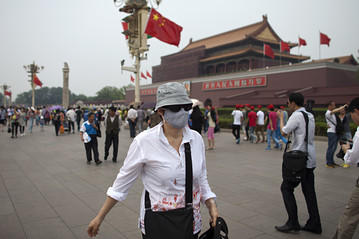 A tourist wearing a mask in Beijing. Source: (Deng, 2013)