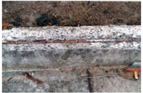 shows reinforcing steel exposed and corroding.