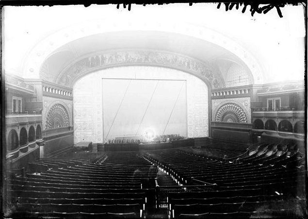 Auditorium Theater, View Looking from the Back of the Theater Over the Rows of Seats on the Main Floor Toward the Curtained Stage. (Chicago Daily News, Inc., photographer).