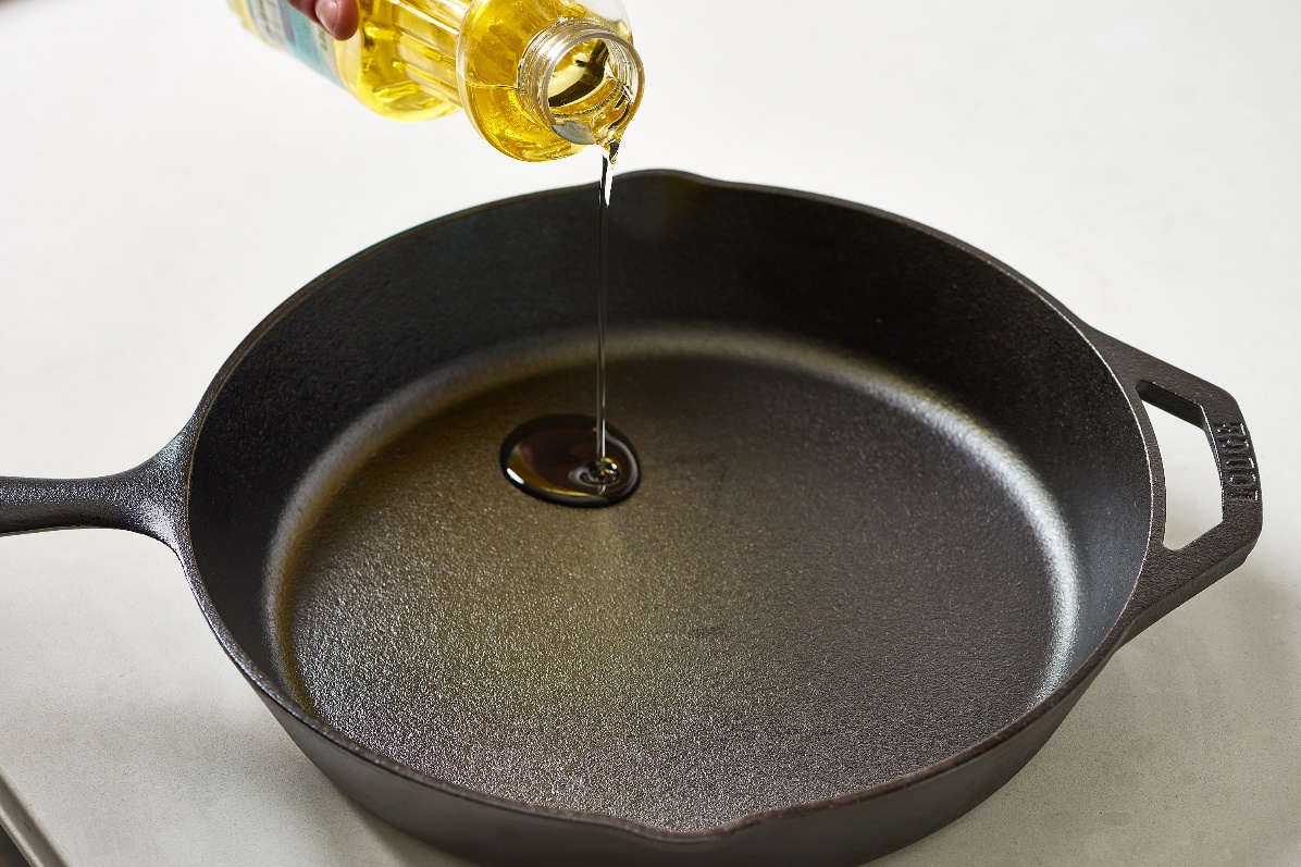 A skillet seasoned by olive oil.