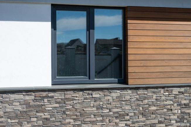 There are three types of cladding materials on a single wall: putty, timber, and stone