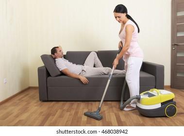 Vacuuming Woman Resting Man