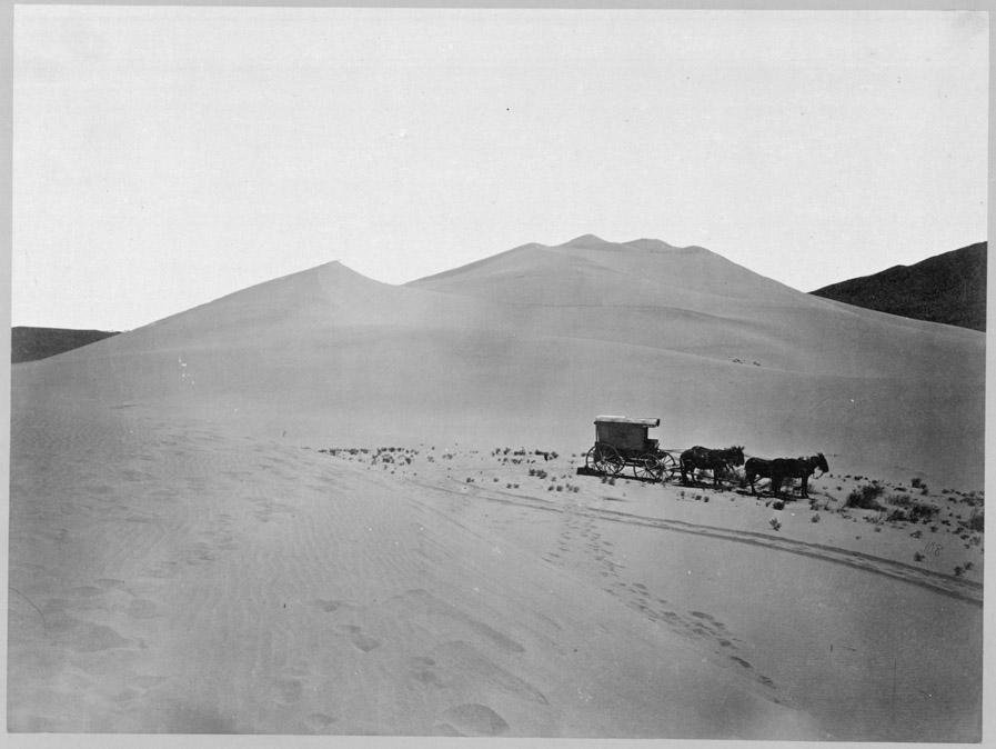 Timothy O'Sullivan's ambulance wagon and portable darkroom used during the King Survey rolls across the sand dunes of Carson Desert, Nev.